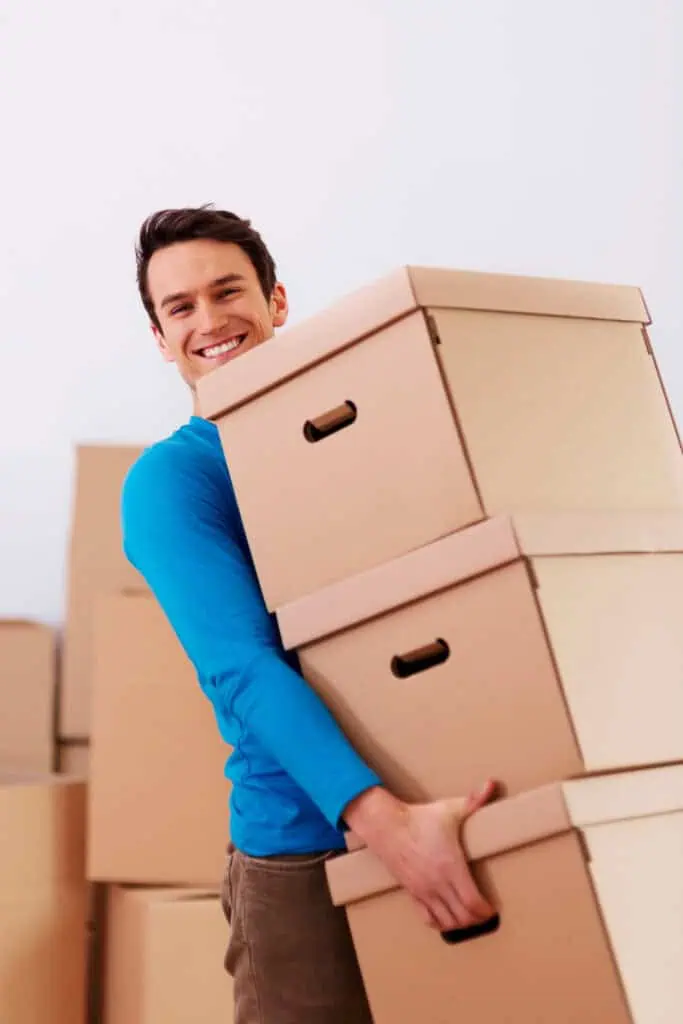Relocation specialist moving stacked up boxes with smile