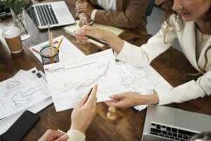 People working in elegant and cozy office space, discussing reports on papers