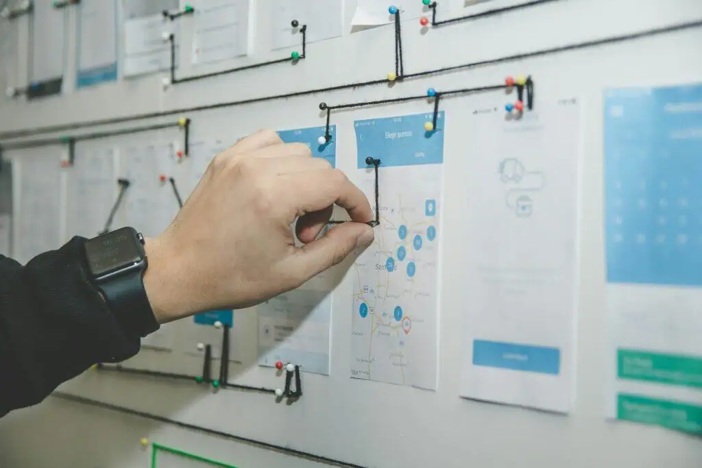 A hand pointing at a map on a board