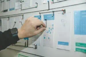 A hand pointing at a map on a board