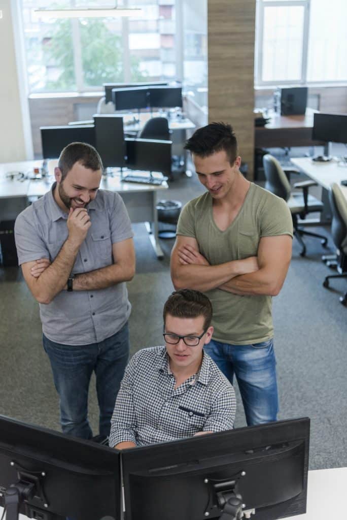 Three male design engineers working as team in office to find solution to problem