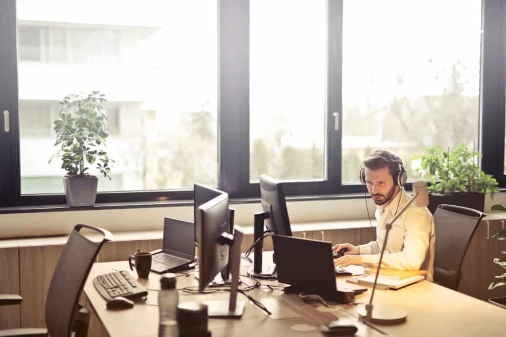 IT support service professional with headset on working at his computer in empty office